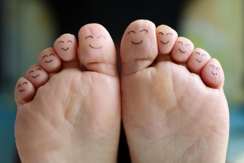 Feet with smiley faces drawn on each toe